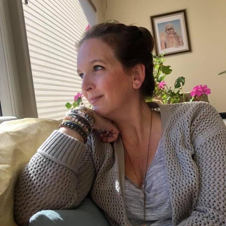 Angie Pizzeck resting her chin on her hand, looking toward a sunlit window